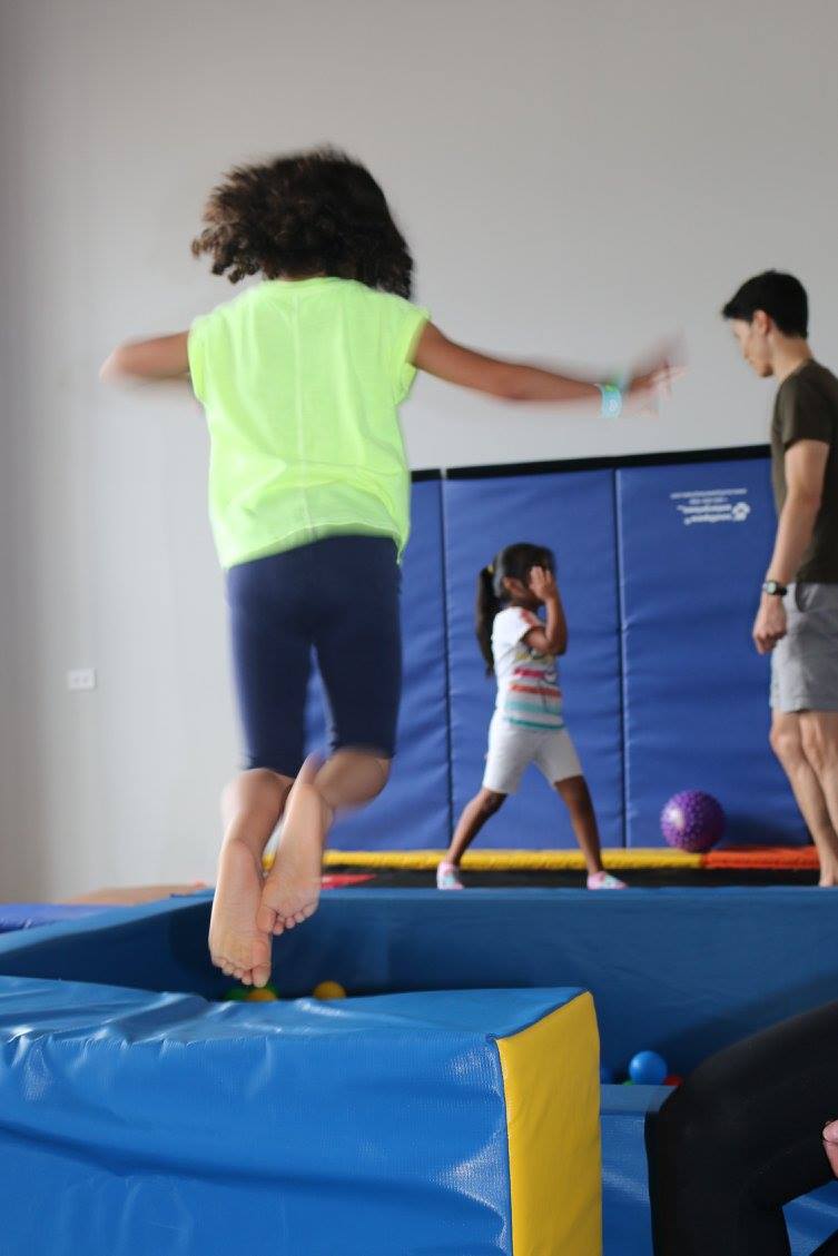Children jumping on a trampoline with a physical therapist Children jumping on a trampoline with a physical therapist