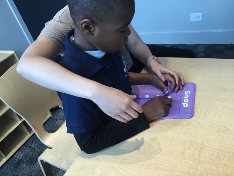 Child working on buttoning in occupational therapy session