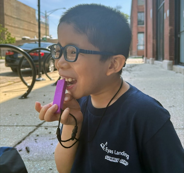 Child chewing on purple Chewelry